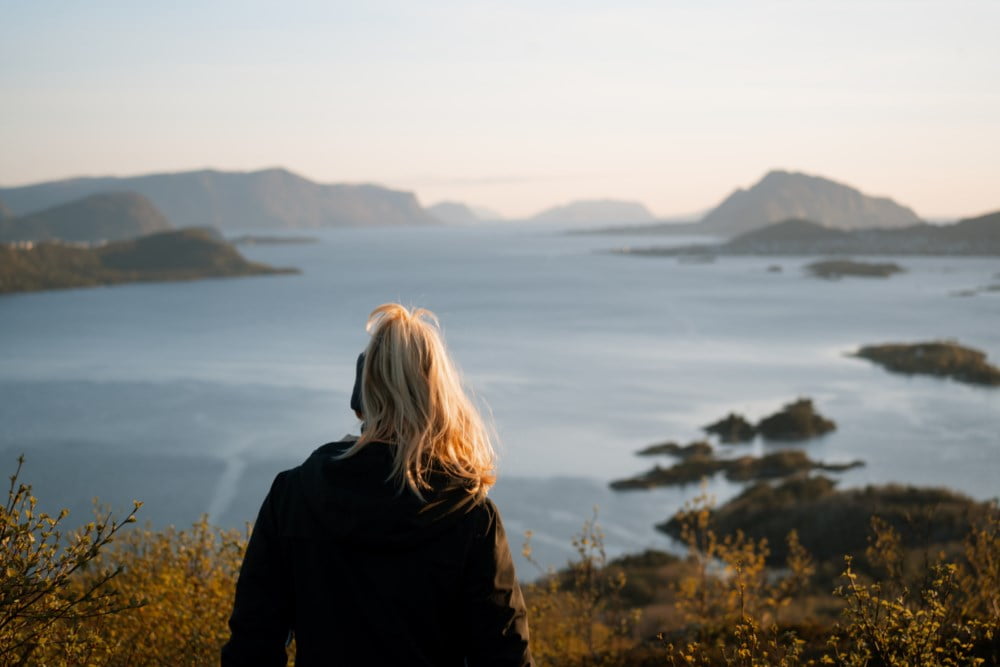 Noen som stryker en person som ligger i en sykehusseng på hånden.