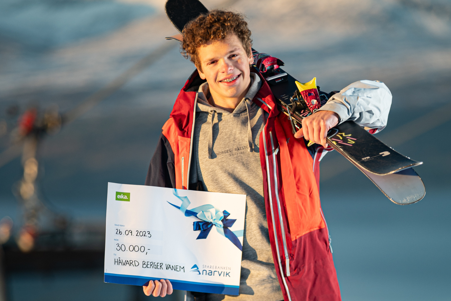 Håvard Berger Vanem med ski på ryggen og gavesjekk fra banken