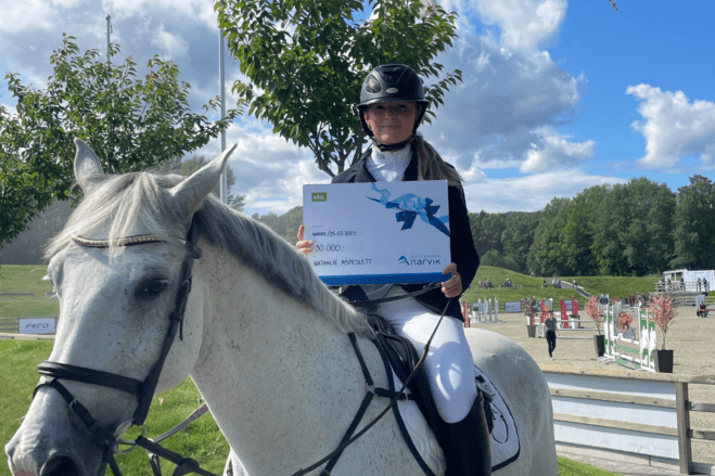 Stipendvinner Nathalie Aspeslett på hesten sin med talentstipend i hånda
