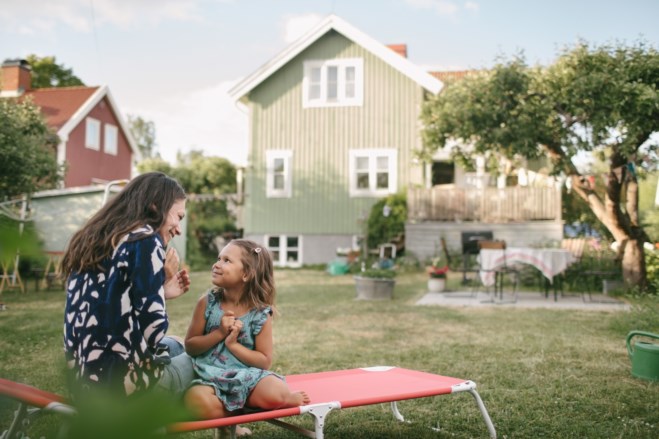 Mor og barn foran hus