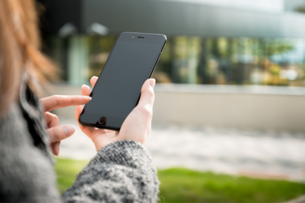 Jente holder telefon