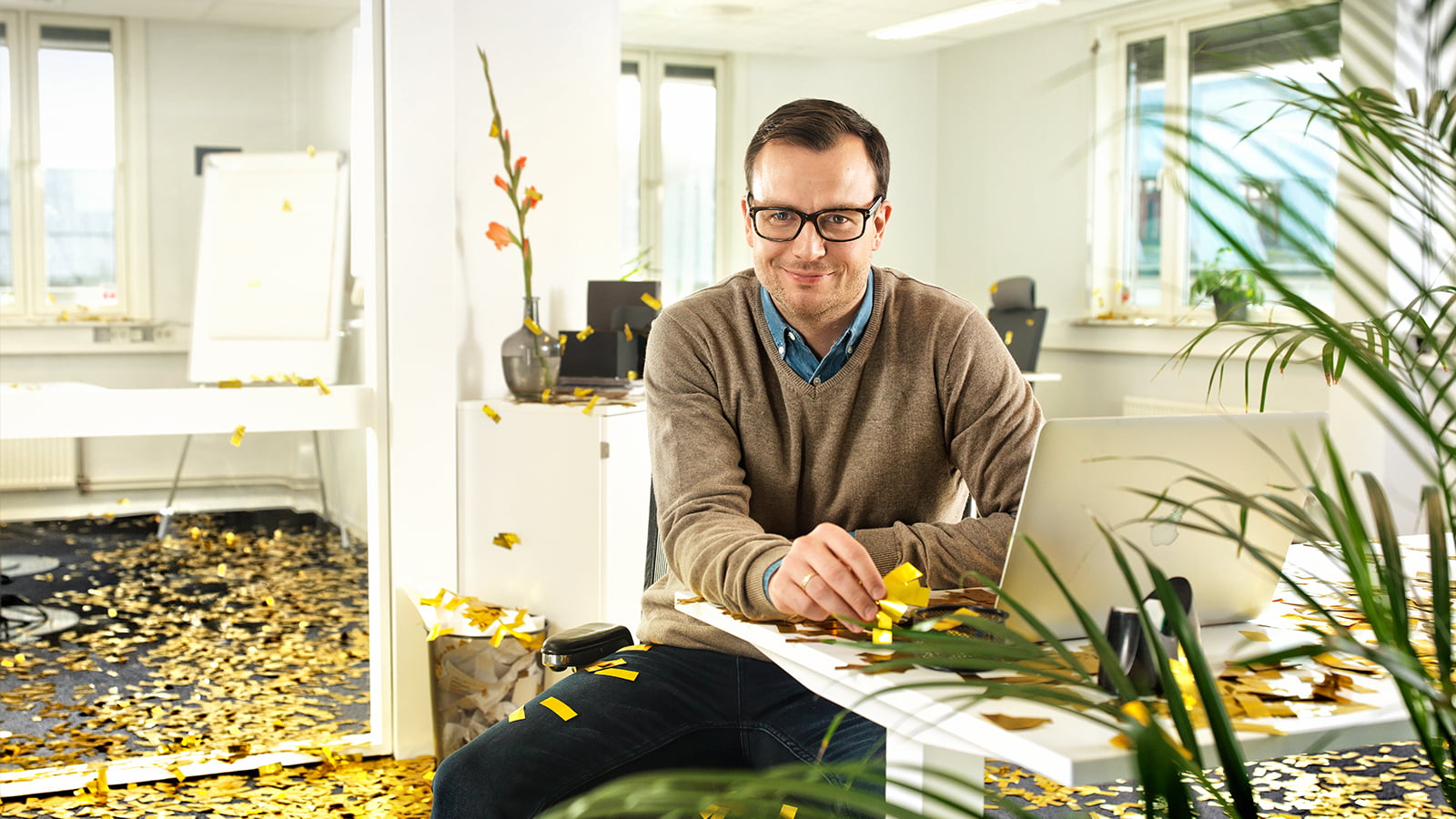 Mann bak PC på kontor, glitter på bakken